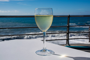 Summer holiday on sea, drinking white wine on outdoor terrace with sea view in sunny day