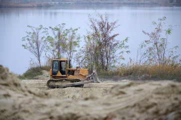 Quarry aggregate with heavy duty machinery. Caterpillar loader Excavator with backhoe driving to...