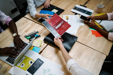Faceless office employee showing chart to coworkers