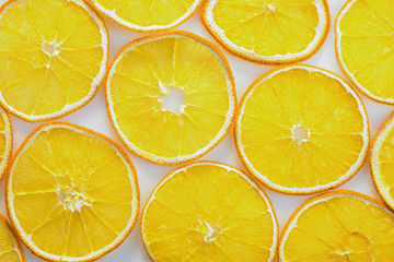 Slices of dry orange are laid out on a white background. Dry fruit background