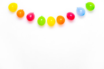 Colorful balloons on white wall or table top view. Festive or party background. Flat lay style. Copyspace for text. Birthday greeting card