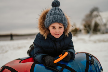 smiling boy sitting in the tubing bun and looking at the camera