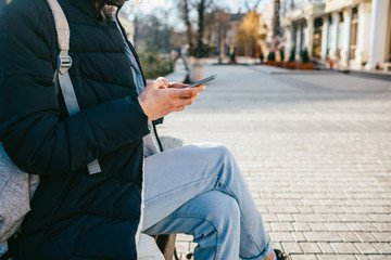Side view of young woman sitting on bench
