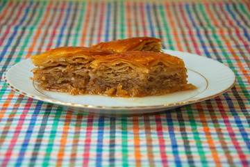 Homemade Turkish dessert or baklava on a serving plate in close-up
