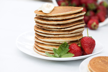 Homemade pancakes with fresh strawberries and honey.