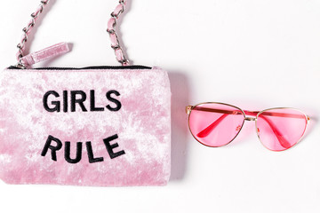 Pink velvet bag with golden chains and girl rule text on a white background