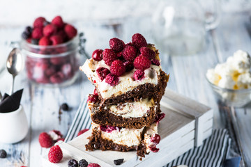 Cheesecake brownies with raspberry stacked on a plate. Melting chocolate. Piece of cake. Brownie...