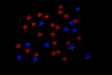 Fototapeta na wymiar scattering of sequins in the form of blue stars, isolate on a black background