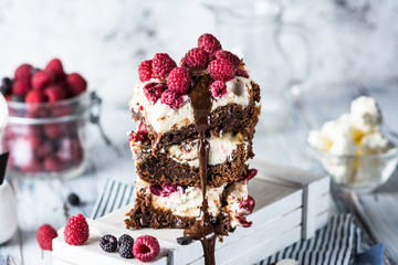 Cheesecake brownies with raspberry stacked on a plate. Melting chocolate. Piece of cake. Brownie...