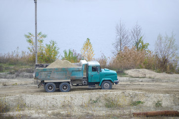 Dump truck transports sand and other minerals in the mining quarry. Heavy industry