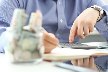 Fototapeta na wymiar Male hand using calculator counting financial expenses closeup