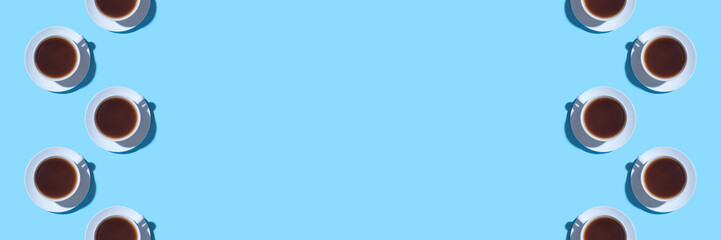 Frame of cups of black coffee or tea on a blue background. Flat lay, top view. Copy space for text.