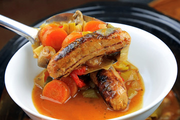 Grilled pork sausage with vegetables making up a sausage casserole.