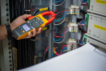 Electrical engineering uses a multimeter to measure the electrical current of wires.