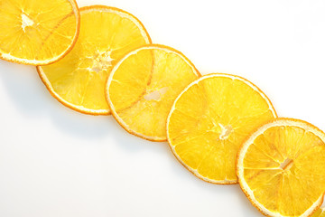 Circles of dry orange slices on white background.