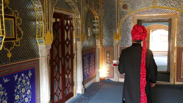 India, Rajasthan, Jaipur, Samode Palace, Waiter carrying Tea Tray in ornate passageway - Model released