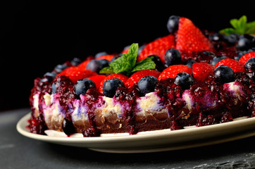 Fresh strawberries, blueberries and cherry jam tart. Dark background. Low depth of field