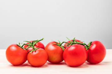 Branch of red tomatoes on a wooden table