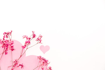 A large pink heart with a place for text decorated with small pink flowers on a white background