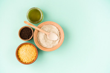 Cosmetic bath salt, grape gomaj for the face, coffee scrub for the body on a mint background. Spa...