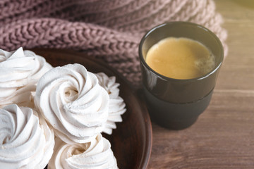 Handmade apple white homemade marshmallows on a brown plate and coffee in a black mug on a wooden...