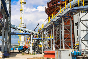 A large powerful industrial installation at an oil refining petrochemical chemical plant with pipe equipment, metal columns, barrels, barrels and equipment