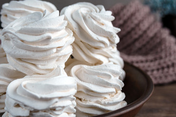 Handmade apple white homemade marshmallows on a brown plate and coffee in a black mug on a wooden...