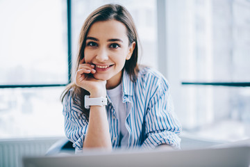 Cheerful young woman in office - obrazy, fototapety, plakaty