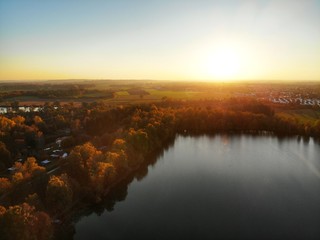 Naklejka na ściany i meble Sunset with a drone from above a lake in autumn 