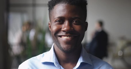 Happy confident young african businessman looking at camera in office