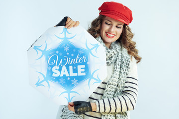 smiling stylish woman looking at winter sale banner