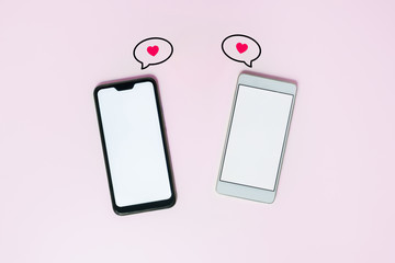 Two phones with white screens and messaging icons. Messaging, love texting and online dating concept. St. Valentine's day concept