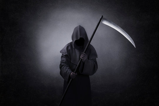 Grim reaper with scythe in the dark