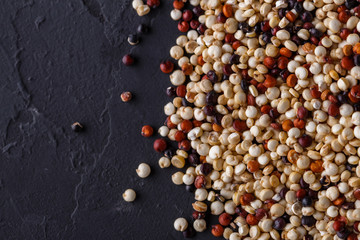 mix of quinoa grains on a dark stone background