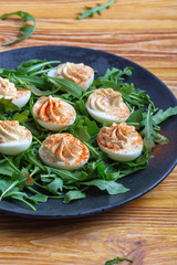 Deviled eggs with paprika on fresh arugula salad