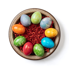 Different easter eggs in ceramic bowl isolated on white