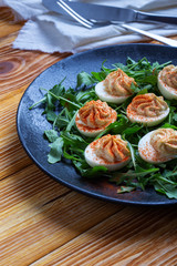 Deviled eggs with paprika on fresh arugula salad