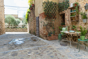 Quaint corner with table and chairs in Monteriggioni, Italy