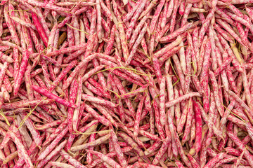 A table is filled with cranberry beans for sale at a market