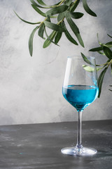 Exotic blue wine, trendy non-classical drink in wine glass on gray background