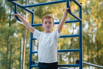 Fototapeta premium Little boy playing sports on street public sports simulators