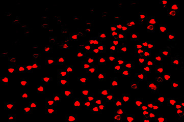 Naklejka na ściany i meble Festive black background from decorative red hearts.Holiday background for packaging and projects.Copy space