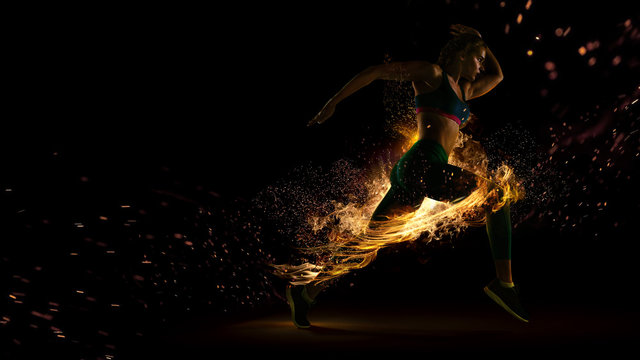 Sport. Runner. Side view of a jogger athlete with the power isolated on black. Fire and energy