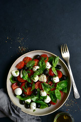 Fototapeta na wymiar Caprese - traditional italian vegetable salad with mozzarella cheese. Top view with copy space.