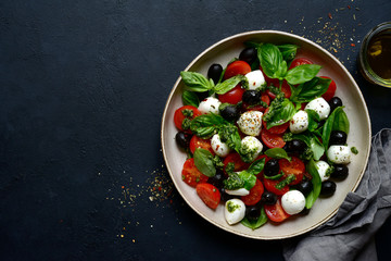 Caprese - traditional italian vegetable salad with mozzarella cheese. Top view with copy space.