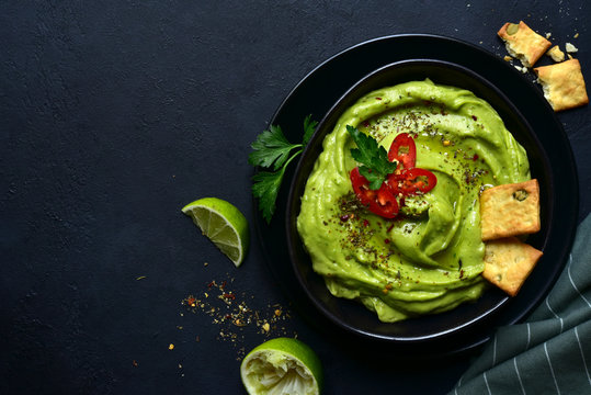 Guacamole - traditional mexican spicy avocado dip. Top view with copy space.