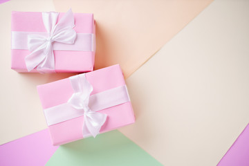 Creative background, holiday present. Handmade paper gift boxes on multicolored backdrop....