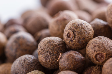 fresh spicy peppers allspice on white acrylic background