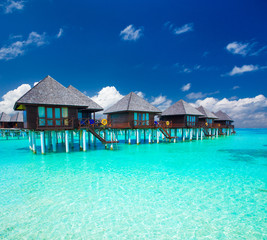 Beautiful tropical Maldives island with beach. Sea with water bungalows