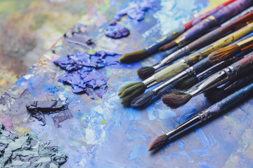 Fototapeta premium Paint brushes on palette, close up